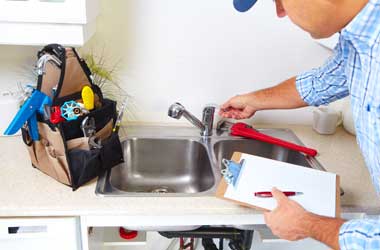 Plumber Inspecting a Kitchen Faucet in Houston
