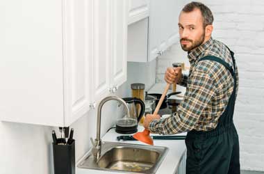 Plumber Unclogging a Kitchen Sink Drain in Houston
