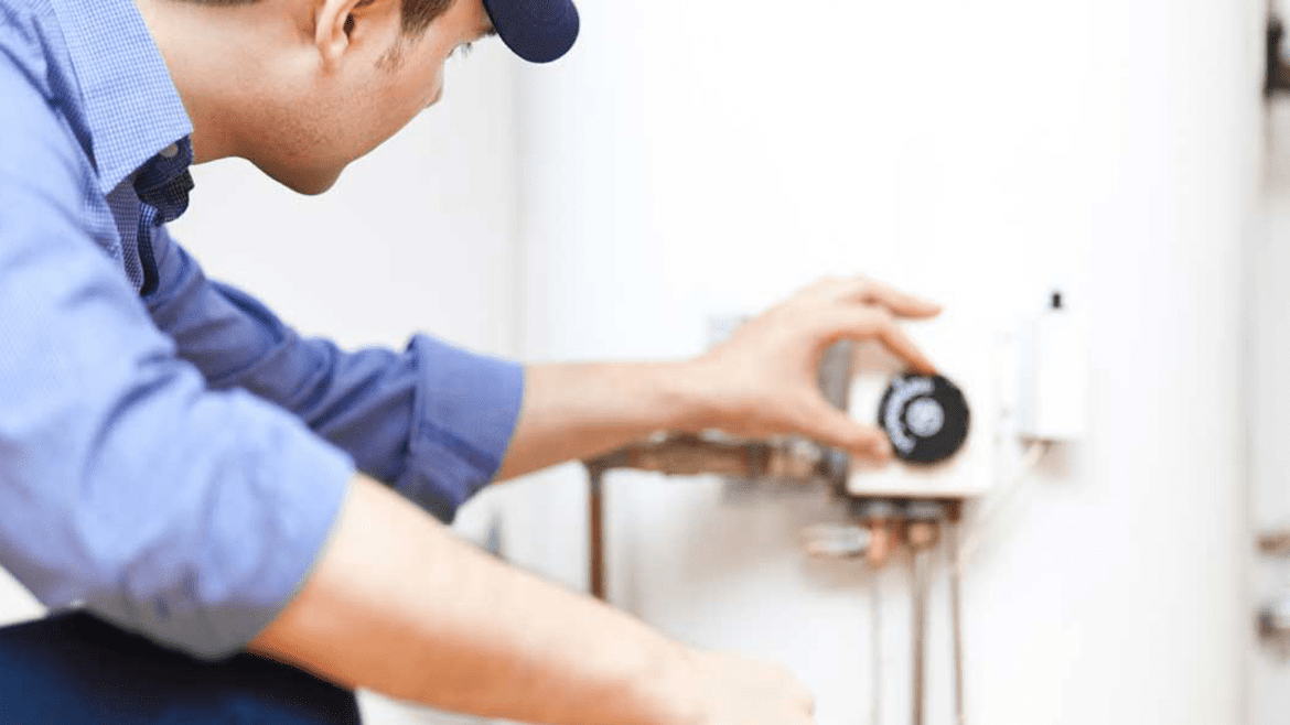 Plumber Inspecting a Water Heater to Determine if It Needs Replacement